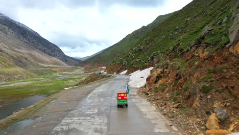 Tracking-drone-shot-of-a-Tuk-Tuk-on-the-Babusar-Pass-mountain-pass-in-Pakistan,-in-the-Kaghan-Valley