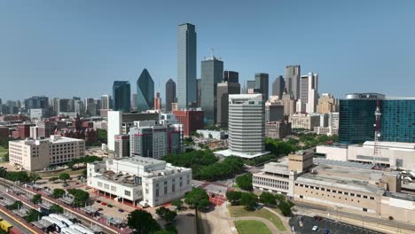 Aerial-pullback-reveal-of-downtown-Dallas-Texas-building,-rail-yard,-railroad,-office-building-skyscraper-highrise-complex