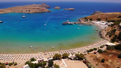 Aerial-View-Of-Beautiful-Beach-In-Lindos-On-Rhodes-Island,-Greece---drone-shot