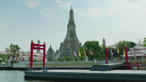 4k-Filmische-Religiöse-Reiseaufnahmen-Des-Buddhistischen-Tempels-Wat-Arun-In-Bangkok,-Thailand-An-Einem-Sonnigen-Tag-Von-Einem-Boot-Auf-Dem-Fluss-In-Zeitlupe