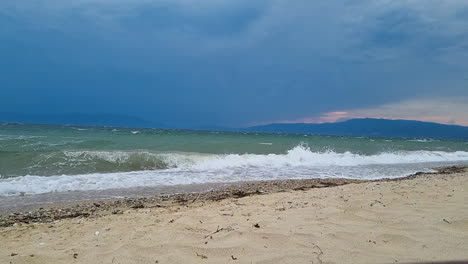 Sandy-beach-with-sea-waves-and-stormy-clouds-in-the-sky