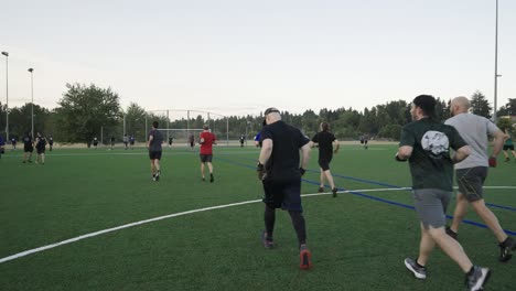 Reife-Männer,-Die-Auf-Einem-Fußballfeld-Laufen-Und-Joggen