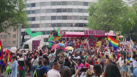 Camión-Con-Escenario-Que-Lleva-A-Los-Artistas-Del-Desfile-Del-Orgullo-Pasando-Por-Una-Gran-Multitud-A-Lo-Largo-De-La-Avenida-Juárez-Ondeando-Banderas-Del-Arco-Iris-En-La-Ciudad-De-México