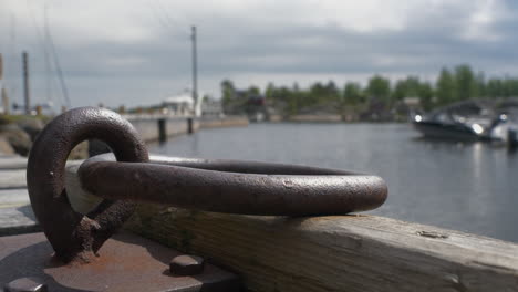 Rusty-metal-ring-eye-for-ships-and-boats-in-Swedish-harbor,-close-up-view