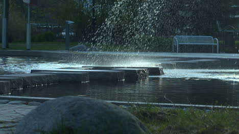 Zeitlupe-Wasser-Aus-Parkbrunnen-Fällt-Auf-Große-Granitplatten-Im-Pool