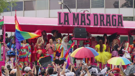 Close-Up-View-Of-Stage-Carrying-Pride-Parade-Performers-Past-Large-Crowd-Along-Avenue-Juarez-Waving-Rainbow-Flags-In-Mexico-City