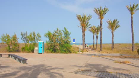 Tiro-Del-Parque-De-Palmeras-Con-La-Vista-Del-Agua-De-Mar-En-La-Distancia-En-La-Playa-De-Playa-El-Pinar-En-El-área-De-Grau,-Castellon,-España