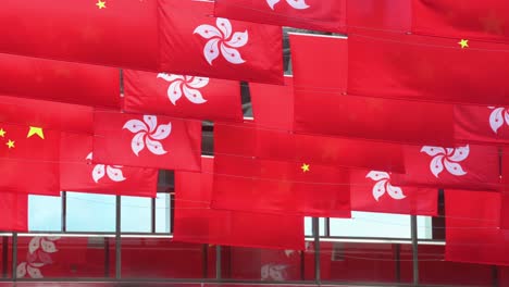 Ein-Pendler-Geht-Durch-Eine-Fußgängerbrücke,-Während-Die-Flaggen-Der-Volksrepublik-China-Und-Der-Hongkong-Sar-Vor-Dem-1.-Juli-Der-übergabe-Hongkongs-An-China-In-Hongkong-Gezeigt-Werden