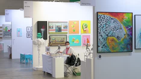 Art-exhibitor-salespeople-are-seen-in-their-booth-ready-for-art-buyers-to-arrive-during-a-contemporary-art-fair-show-in-Hong-Kong