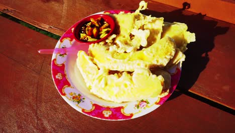 Traditionelle-Indonesische-Snacks,-Gebratene-Banane-Und-Gebratenes-Tempe,-Serviert-Auf-Einem-Teller-Auf-Dem-Holztisch