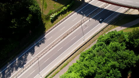 Aerial-view-of-cars-running-on-expressway-with-overhead-bridge-on-bright-sunny-day