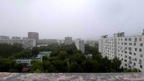 Wide-angle-view-out-of-the-window-of-a-soviet-residential-building-during-heavy-rain-and-thunderstorm-in-Moscow,-Russia-near-Babuskinskaya-metro