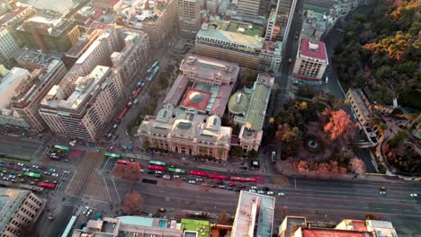 Aerial-orbit-over-the-majestic-neoclassic-National-Library-of-Chile-surrounded-by-Santiago-city-buildings-and-parks-at-sunset