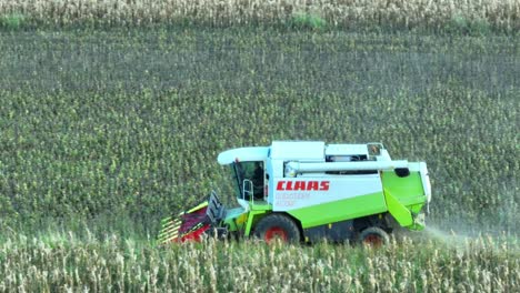 Aerial-tracking-shot-of-Claas-Combine-Harvester-gathering-grain-of-field