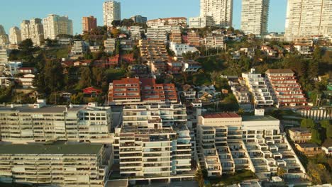 Aerial-view-reversing-away-from-Reñaca-coastal-city-buildings-on-Vina-Del-Mar-beach-resort-waterfront