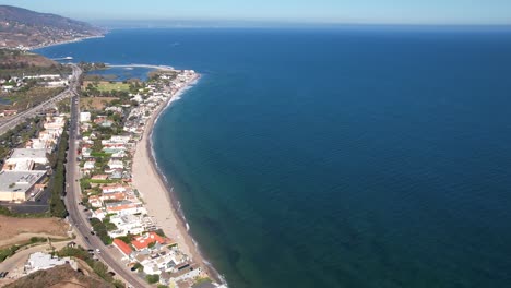 Wide-angle-establishing-aerial-shot-of-Malibu-beach-in-summer,-America