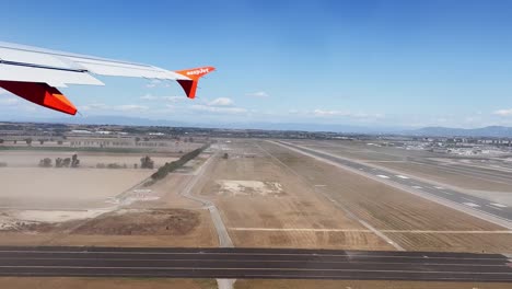 Passenger-pov-of-Easyjet-airplane-wing-while-aircraft-take-off-from-Rome-Fiumicino-Airport,-Italy