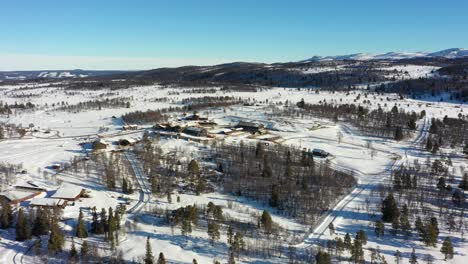 Langedrag-nature-park-distant-aerial-overview-during-sunny-winter-morning---Rotating-to-left-while-keeping-animal-park-in-center---blue-sky-background-Norway