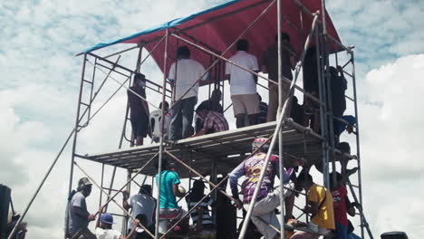 Onlookers,-public-officials,-and-the-media-gather-on-a-small-scaffolding-to-get-a-better-view-of-the-motocross-competition