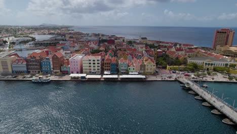 Aerial-approach-to-the-waterfront-houses-in-the-historical-center-of-Willemstad,-Curaçao