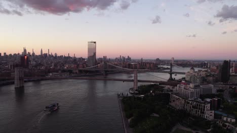 Aerial-view-of-the-Brooklyn-bridge,-vibrant-dusk-in-NYC,-USA---tracking,-drone-shot