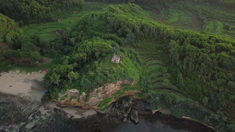 aerial-view-of-a-house-built-on-the-rock-of-a-cliff-on-the-ocean-coast
