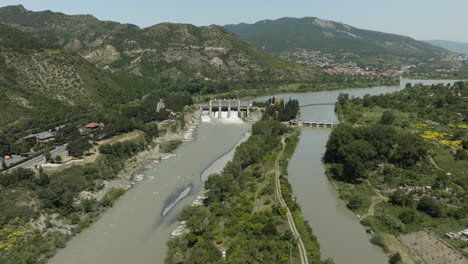 Luftaufnahme-Des-Staudamms-Im-Fluss-Mtkvari-Mit-Blick-Auf-Die-Kaukasusberge-In-Georgien