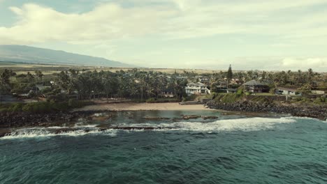 Vista-aérea-zoom-out-de-la-playa-de-Paia,-en-la-isla-de-Maui,-Hawaii,-USA