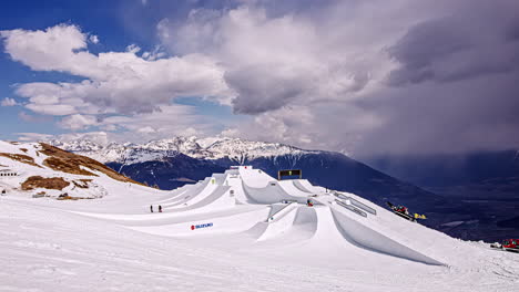 Time-lapse-shot-of-snow-groomers-preparing-jumps-for-Suzuki-Nine-Knights-event,-Watles---Malles-Venosta-ski-resort,-scenic-snowy-alpine-landscape