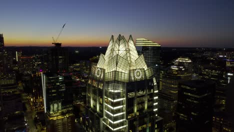 Aerial-view-around-the-Illuminated-Frost-bank-tower-in-Austin,-USA---orbit,-drone-shot