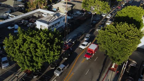 Vista-Aérea-Alrededor-De-Una-Ambulancia-Conduciendo-Por-Las-Calles-De-La-Soleada-Ciudad-De-Los-ángeles,-Estados-Unidos