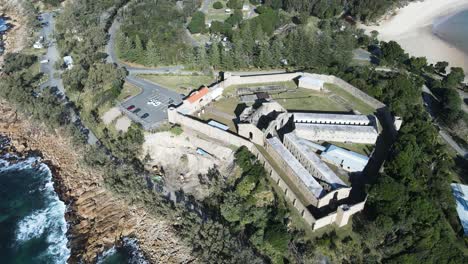 Aerial-view-of-a-heritage-listed-former-public-works-prison-ruins-built-on-a-coastal-headland