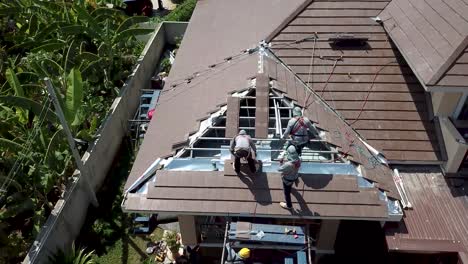 Asian-Technician-Work-on-Roof-Installation,-Aerial-Shot