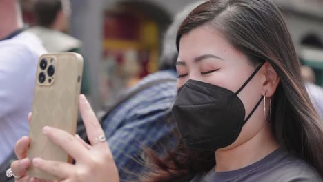 Schöne-Junge-Asiatin-Mit-Gesichtsmaske,-Die-Fotos-Mit-Smartphone-Im-Stadtzentrum-Von-Brüssel,-Belgien-Macht