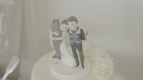 Wedding-cake-with-figure-of-Bride-holding-a-fish-beside-Groom