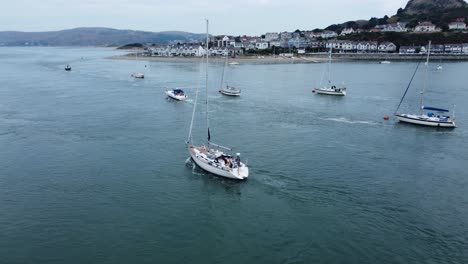Aerial-view-following-above-luxury-sailboat-travelling-along-scenic-river-estuary