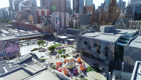 People-walking-around-Federation-Square-in-Melbourne,-Australia-during-summer-activation