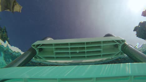 Vista-Submarina-Mirando-Hacia-Una-Escalera-De-Piscina-Con-Burbujas-Provenientes-De-La-Escalera