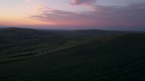 Aerial-180-degrees-pan-over-farm-fields-before-sunset
