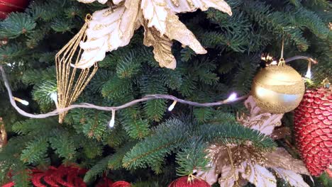 Chic-Christmas-tree-decoration,-glittering-geometrical-spherical-shape,-golden-elegant-ribbon-large-Embroidery-flower-hanging-ornament-and-flashing-lighting