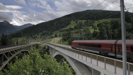 Passenger-train-going-over-a-bridge-in-the-mountains