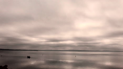 Zeitraffer-Des-Bootes-Im-See-Mit-Vorbeiziehenden-Schweren-Wolken