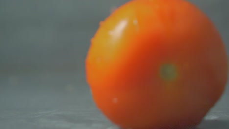 Rote-Tomate-Fällt-Und-Spritzt-Auf-Wasser,-Nahaufnahme-Verschwommen