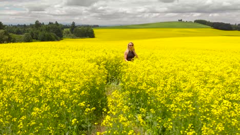 Blonde-girl-walking-in-a-yellow-flower-field