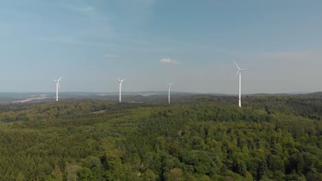 Wide-aerial-landscape-of-wind-turbines,-located-in-the-German-countryside,-bright-summers-day