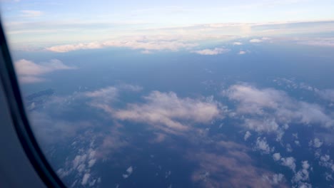 Bright-and-beautiful-blue-sky-landscape,-higher-floating-movement-clouds-and-sun,-space-layer-by-layer,-shoot-an-airplane-window