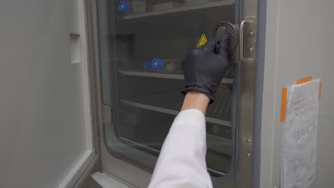 Die-Tür-Zu-Einem-Inkubator-In-Einem-Labor-öffnen-Und-Hineingreifen