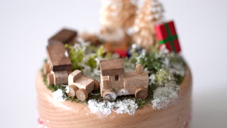 Handmade-wooden-Christmas-music-box,-scene-of-train,-trees-and-gifts-view,-studio-white-background
