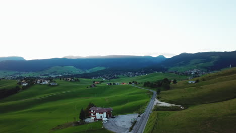 Panoramic-aerial-view-of-green-valley-with-grassy-hills