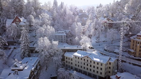 Aerial-push-in-drone-video-of-houses-in-Sankt-Gallen-covered-with-snow,-St